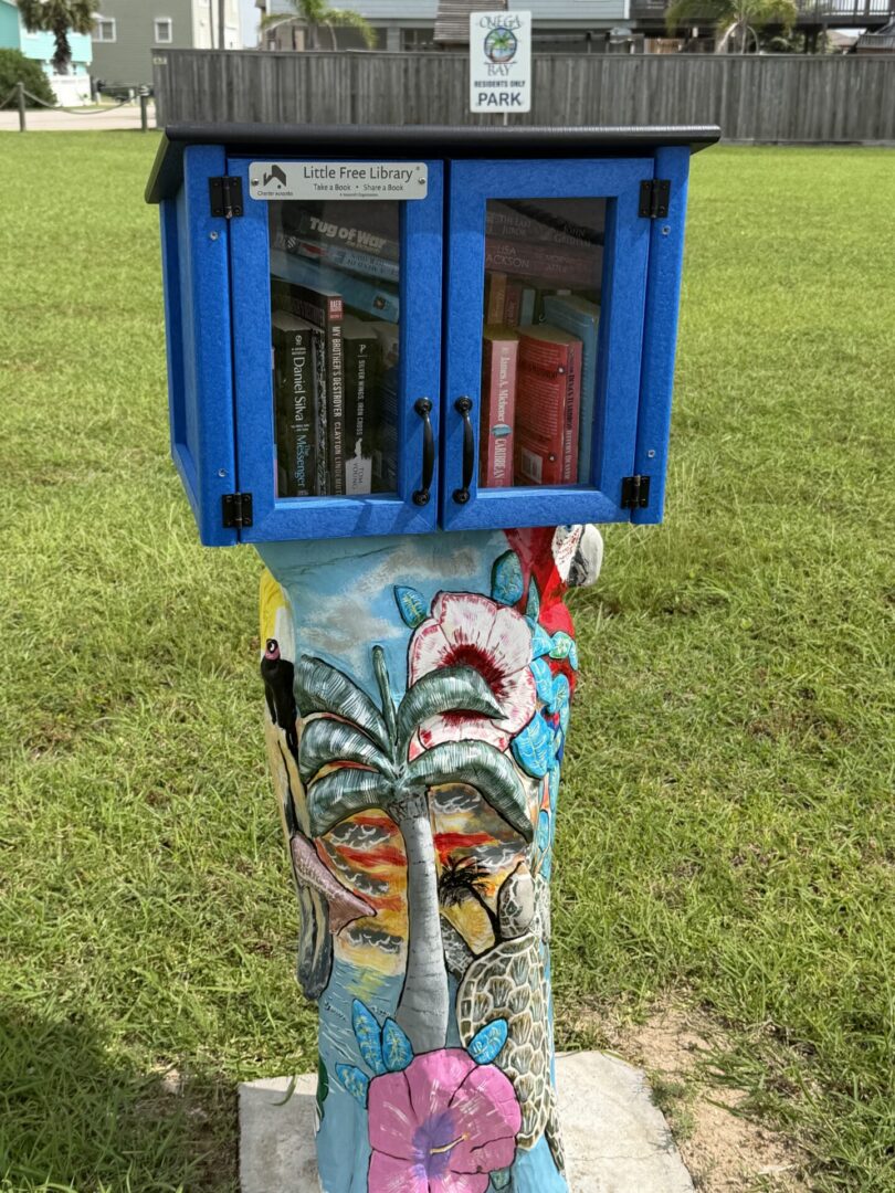 Blue Little Free Library on painted pedestal